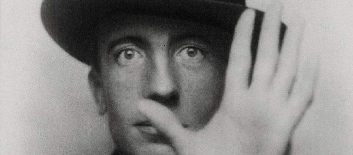 Fotografía en blanco y negro de Paul Eluard con la mano al frente